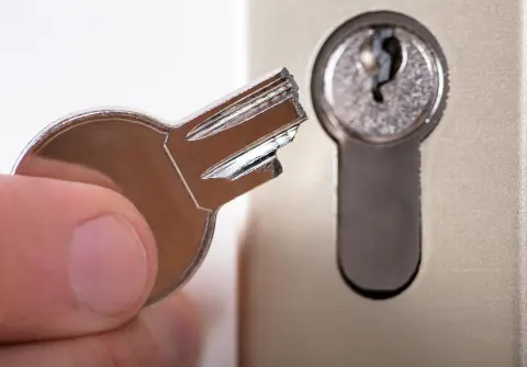 Llave partida junto al cilindro de una cerradura de seguridad